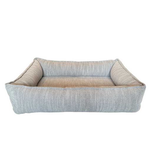 Dog bed with a textured fabric surface on a white background